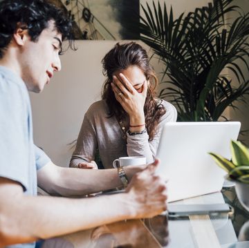 boyfriend with laptop explaining to frustrated girlfriend at home