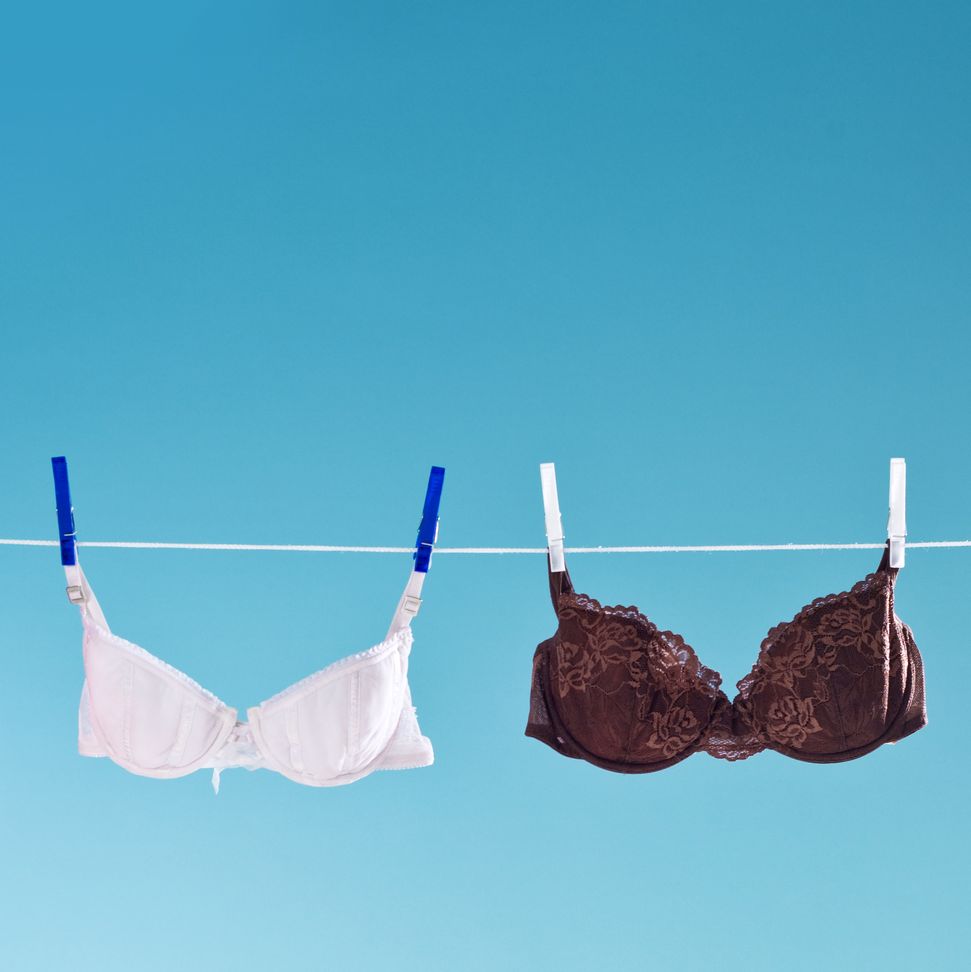 Caucasian woman wearing bra and panties in bedroom - Stock Photo - Dissolve