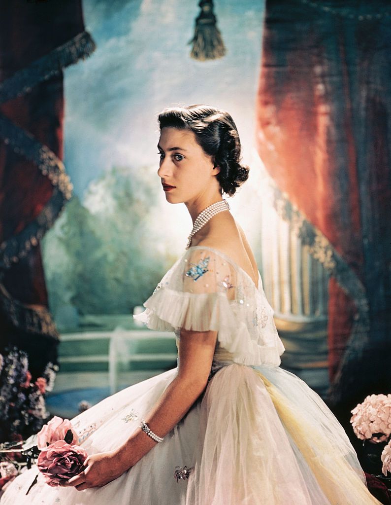original caption princess margaret rose of england, is shown here seated and wearing a formal evening dress with sequence butterflies around the shoulder, and holding two pink roses