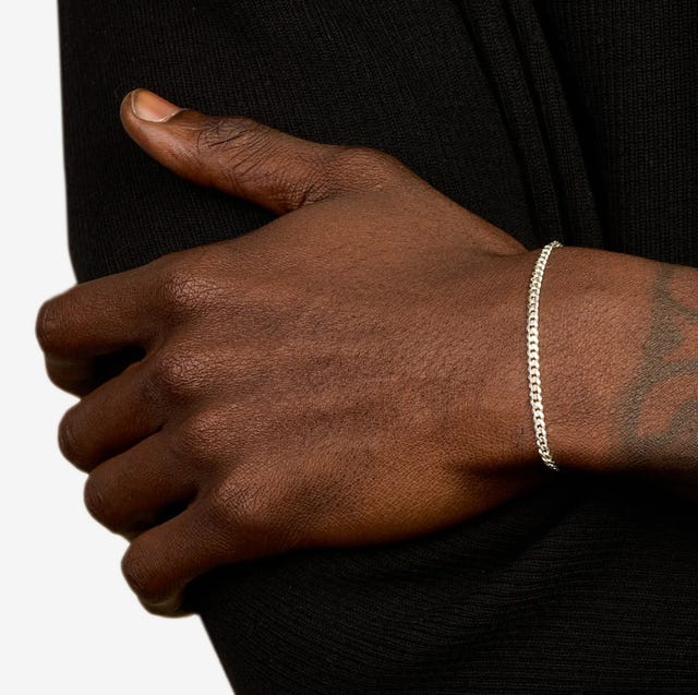 a man wearing a silver cuban chain bracelet a man wearing a silver cuban chain bracelet