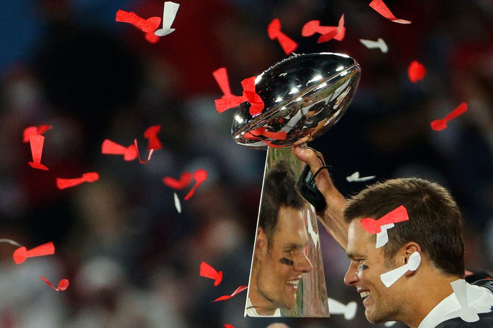 tampa, florida february 07 tom brady 12 of the tampa bay buccaneers celebrates as he is reflected in the lombardi trophy after defeating the kansas city chiefs in super bowl lv at raymond james stadium on february 07, 2021 in tampa, florida the buccaneers defeated the chiefs, 31 9 photo by patrick smithgetty images