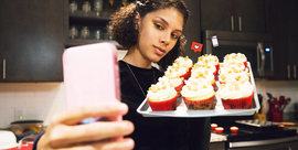 woman taking a selfie with vanilla cupcakes