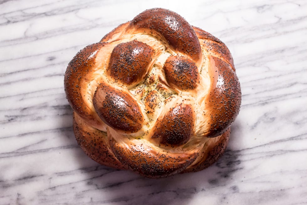 braided round challah bread loaf with poppy seeds