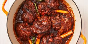 braised lamb shanks in a sauce with carrots and rosemary in a dutch oven