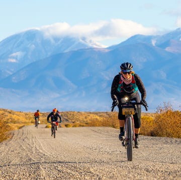 a group of people riding bikes on a dirt road