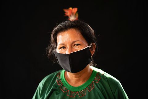 Een lid van de Karapanstam draagt een met de hand genaaid mondkapje in de hoop dat het haar tegen besmetting met het coronavirus beschermt
