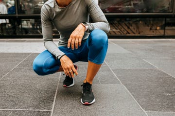 break from the workout runner in blue tights squating on the street