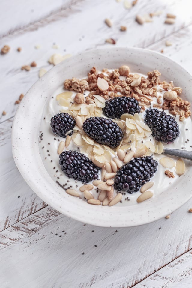 breakfast bowl with homemade granola, dried fruits, blackberries and almond yogurt