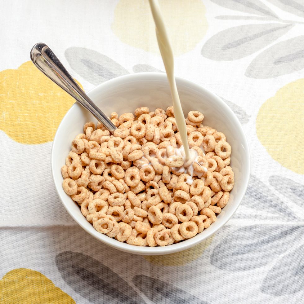 breakfast cereal bowl with cold milk being poured at the morning breakfast table