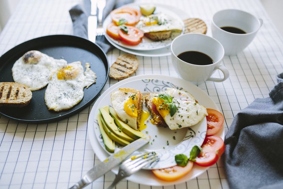 Breakfast for two, eggs, avocado, coffee, tomatoes