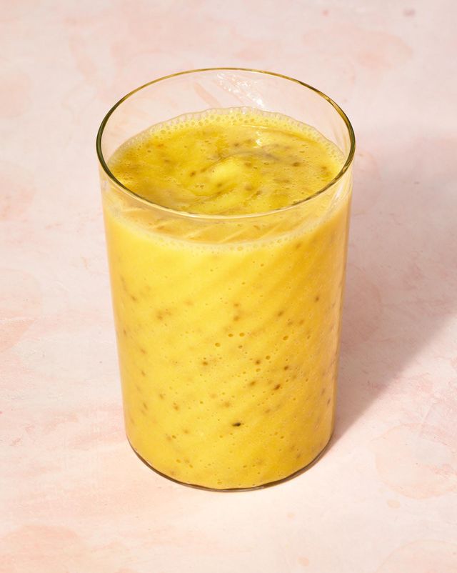 a glass with a bright yellow smoothie