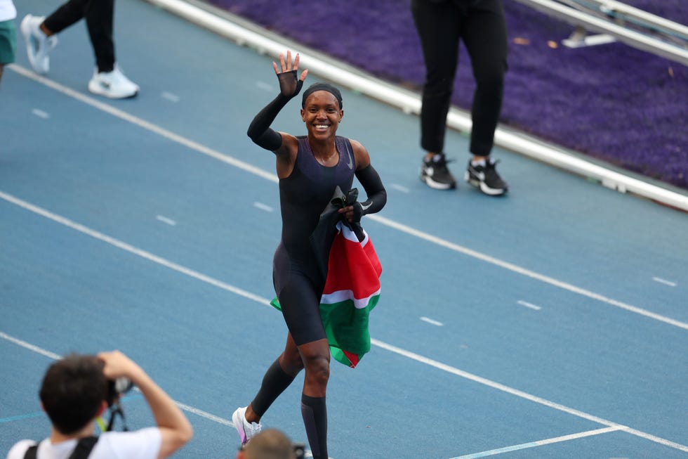 athlete celebrating with a national flag on the track