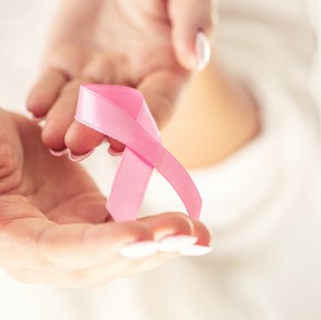 breast cancer symbol pink ribbon in tender female hands october health and medicine concept
