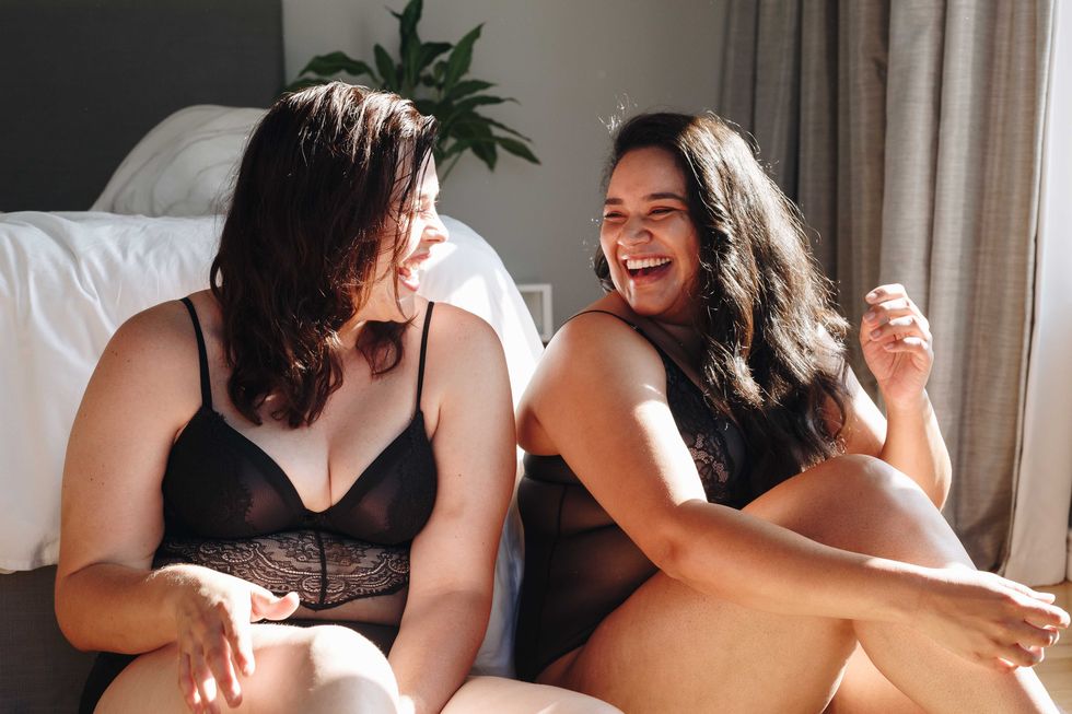 friends in lingerie laughing in bedroom