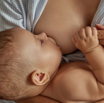 sweet little child, breastfeeding and having nap in mothers arms