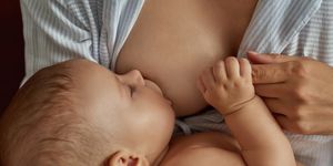 sweet little child, breastfeeding and having nap in mothers arms