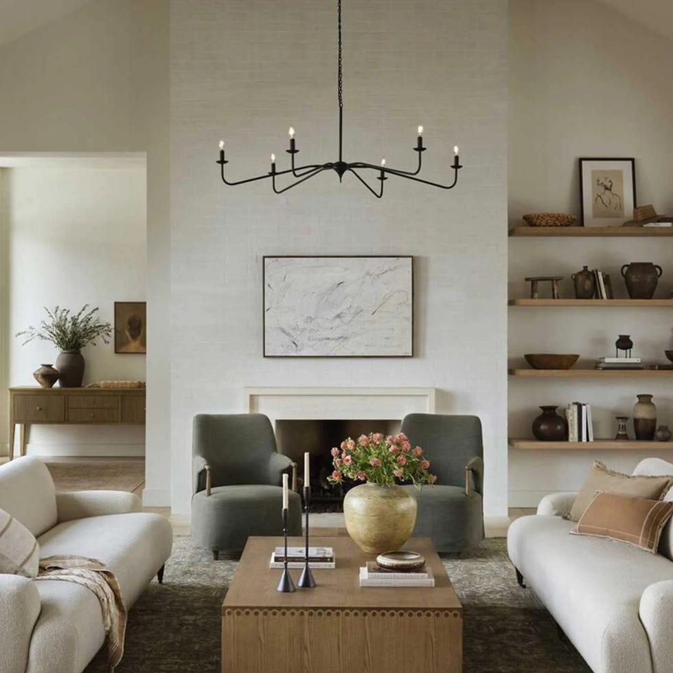 a living room with a chandelier and a table a living room with a chandelier and a table