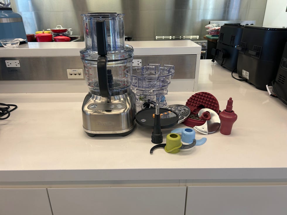 a food processor and its attachments on a kitchen countertop
