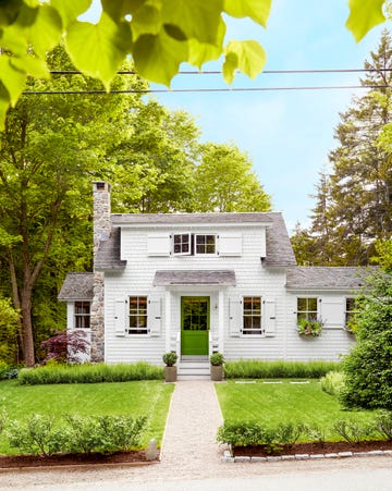 white shingled cottage with bright green door