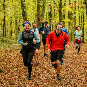 a group of people running in the woods