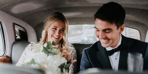 Bride and bridegroom in backseat of car