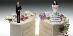 Bride and groom figurines standing on two separated slices of wedding cake