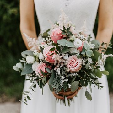 bride holding her bridal bouquet with pink roses and eucalyptus