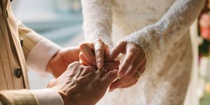 bruid schuift trouwring om de vinger van haar bruidegom