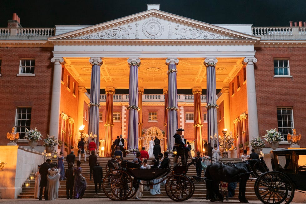 a horse carriage in front of a building with people standing around