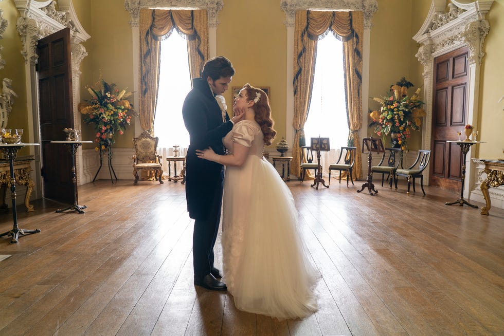 a man and woman dancing in a room with chairs and tables