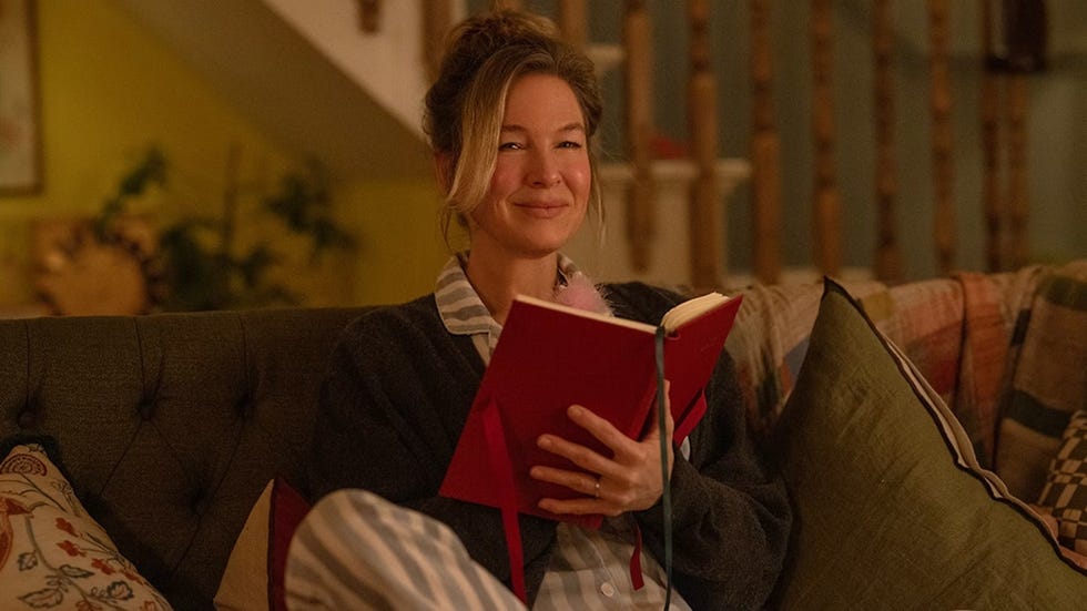 person reading a book while seated on a couch