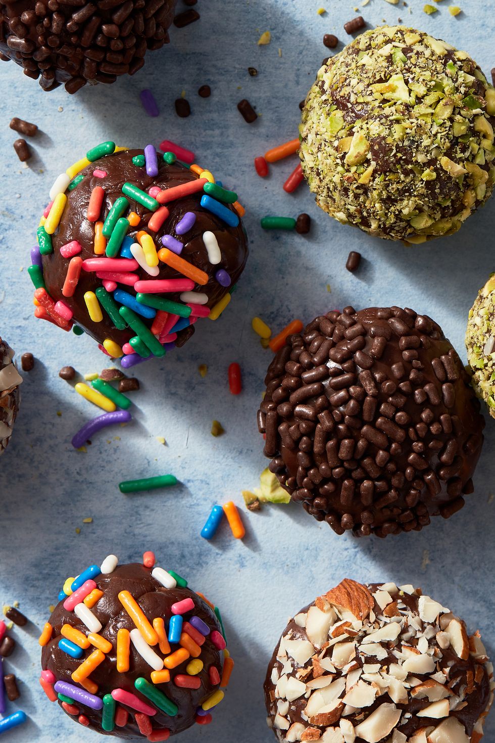brigadeiros covered in chocolate and rainbow sprinkles, pistachios, and almonds