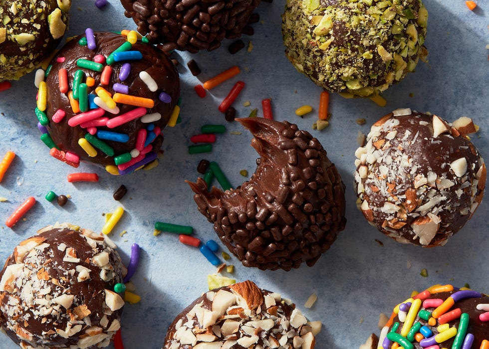 brigadeiros covered in chocolate and rainbow sprinkles, and chopped pistachios and almonds