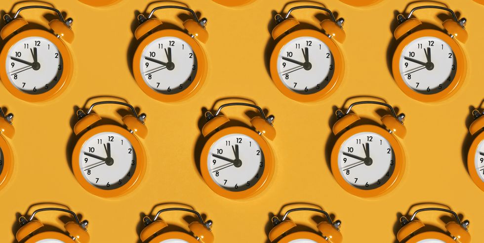 bright alarm clocks on orange background