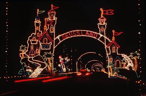 light display that reads seussland in an arch with castle turrets around it and arches of lights following after it
