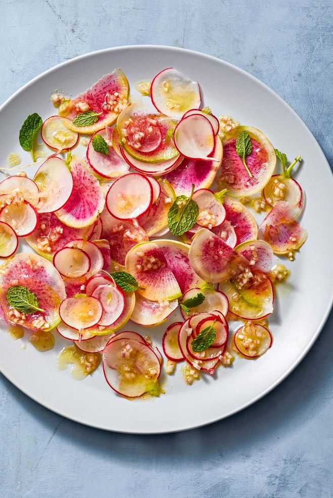 a salad of sliced radishes on a white plate