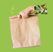 woman's hand holding a brown paper bag