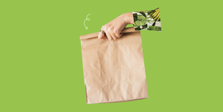woman's hand holding a brown paper bag