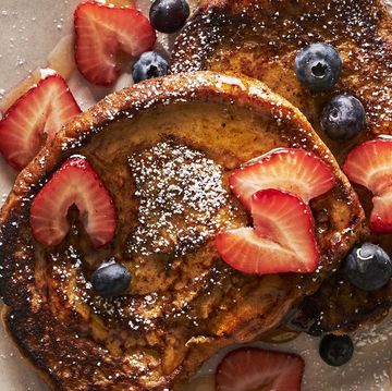 brioche french toast topped with powdered sugar, strawberries, and blueberries