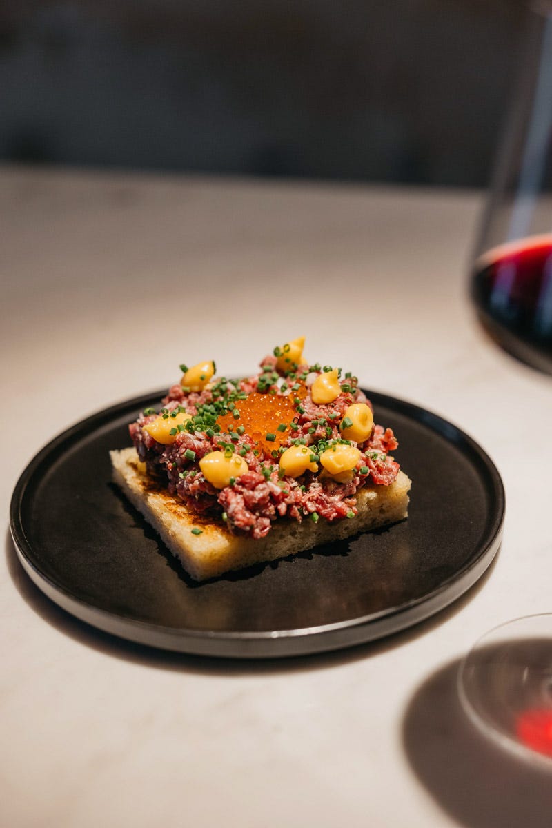 plato de brioche de steak tartar con copa de vino