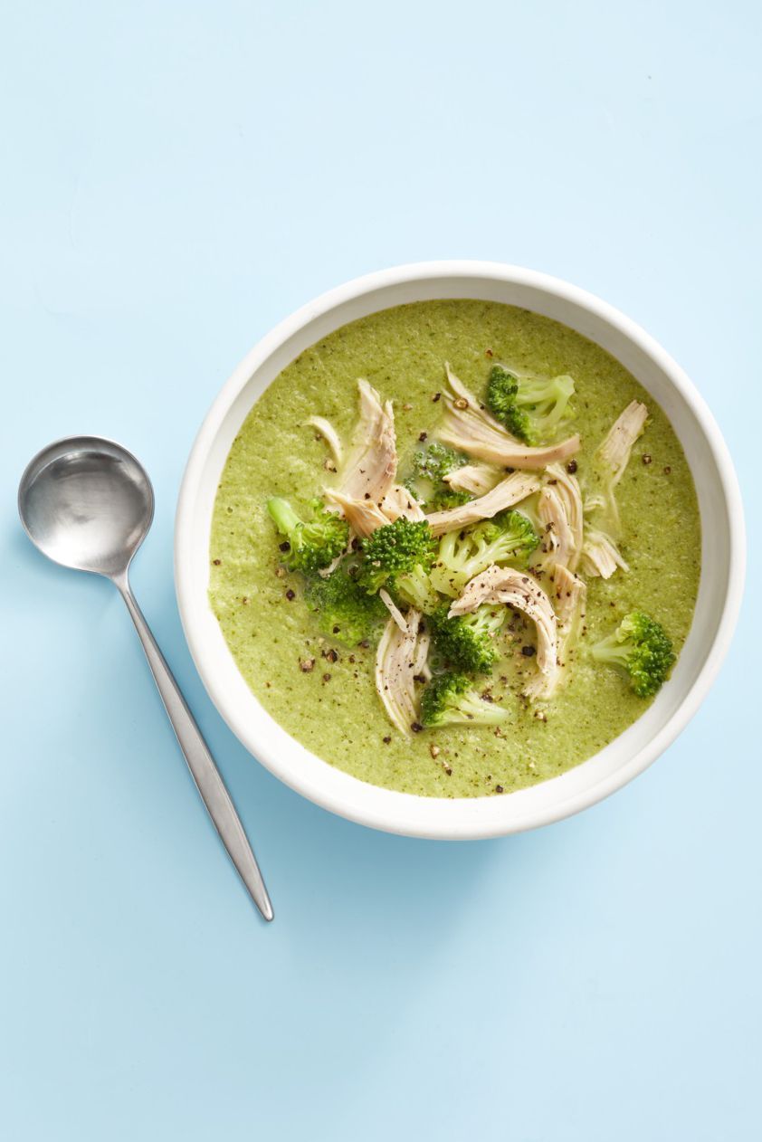 healthy broccoli soup with shredded chicken breast on top in a white bowl