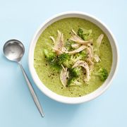 healthy broccoli soup with shredded chicken breast on top in a white bowl