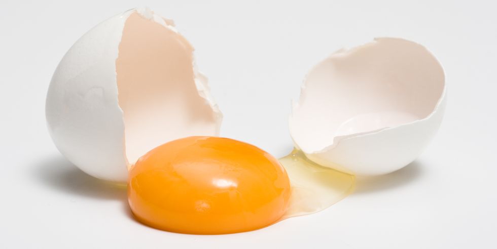 broken eggshells next to egg yolk
