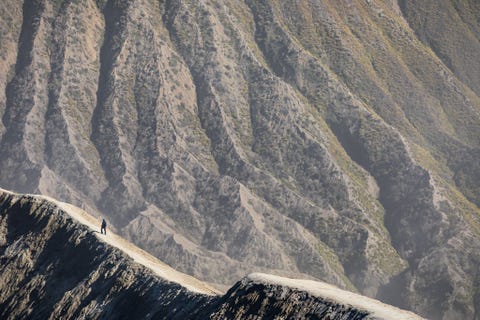 https://www.nationalgeographic.com/content/dam/travel/rights-exempt/2018-travel-photographer-of-the-year/magical-mountains/bromo-caldera-java-indonesia.jpg Al trekkend door een van de mooiste landschappen ter wereld bij de kraterrand van de Bromo op Java in Indonesi
