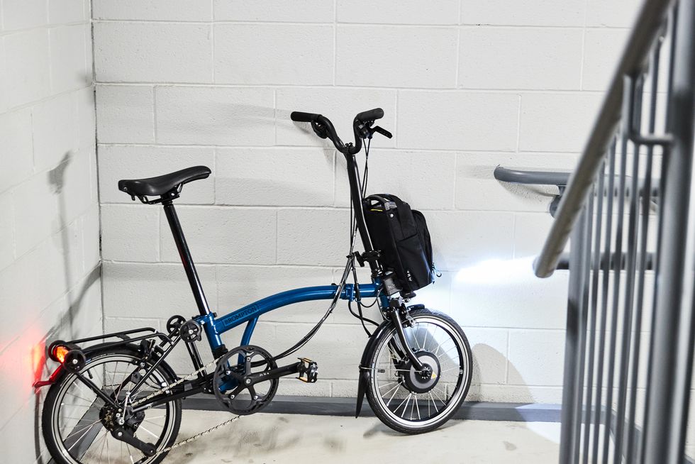 brompton c line electric folding bike parked in stairwell