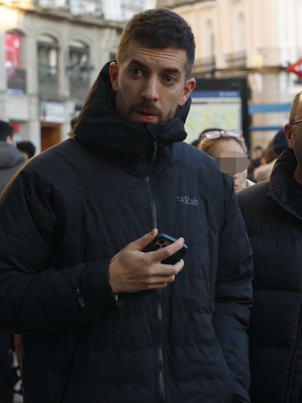 a group of individuals standing outdoors with one person holding a smartphone