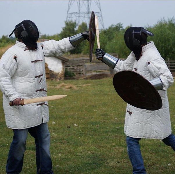 two archaeologists staging a sword fight