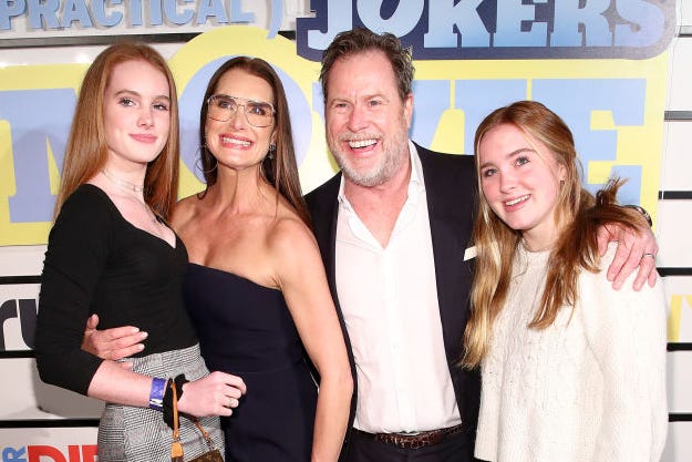 rowan henchy, brooke shields, chris henchy, and grier henchy pose for a photo, everyone is smiling and hugging and wearing black or white outfits