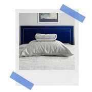 grey heathered cashmere sheets on bed with blue velvet headboard