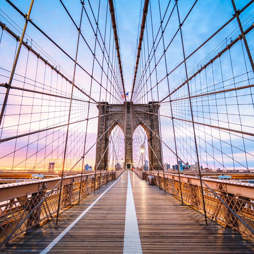 brooklyin bridge's pedestrian walkway at sunrise, new york city